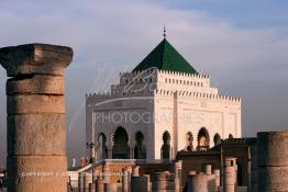 Image du Maroc Professionnelle de  Le tombeau du plus populaire des sultans du Maroc, Mohammed V, père de l’indépendance repose ici dans cette  demeure bâtie en marbre blanc et couronnée par un toit pyramidale orna de tuiles vertes, symbole de la royauté. Sa construction a nécessita une dizaine d’année, au premier plan  les colonnes de l’esplanade de la Mosquée Hassan à Rabat, Jeudi 1er Mars 2007. (Photo / Abdeljalil Bounhar)
 